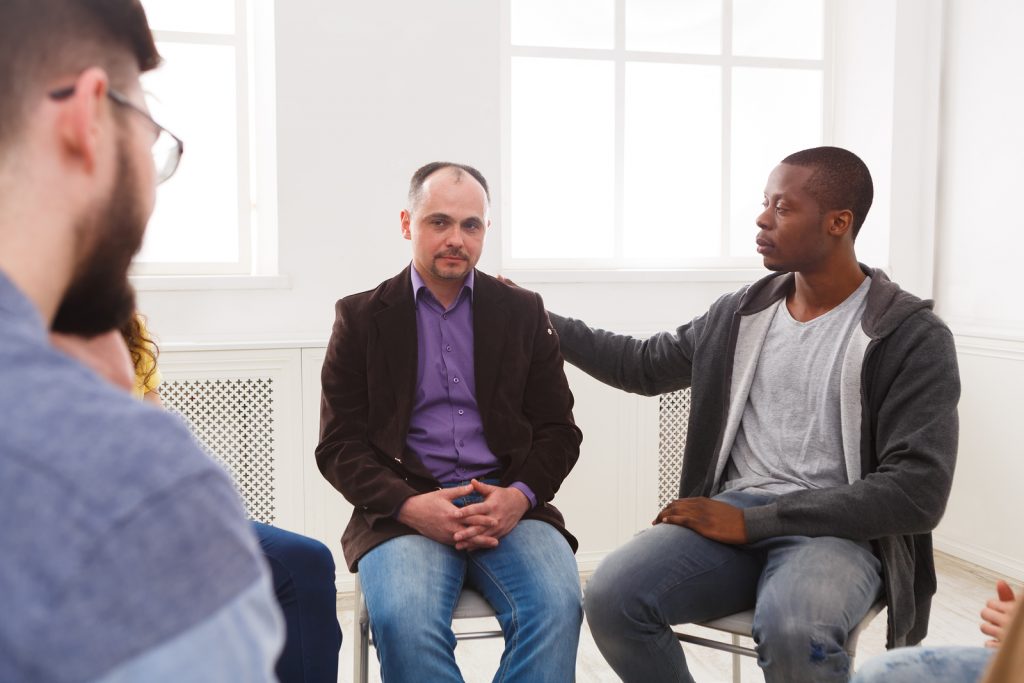 Meeting of support group. Depressed man sitting at rehab group therapy. Psychotherapy, depression, life issues concept