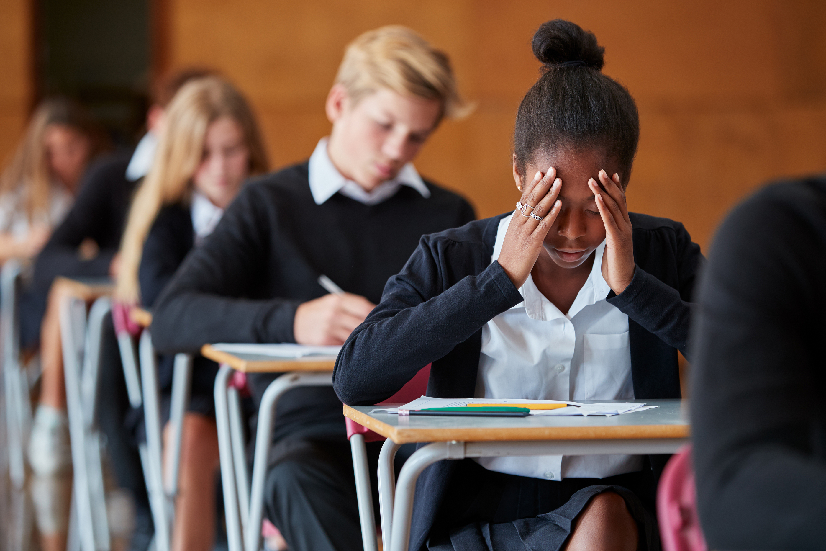 Anxious Teenage Student Sitting Examination In School Hall