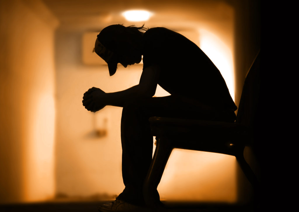 Young man with hands clasped together praying