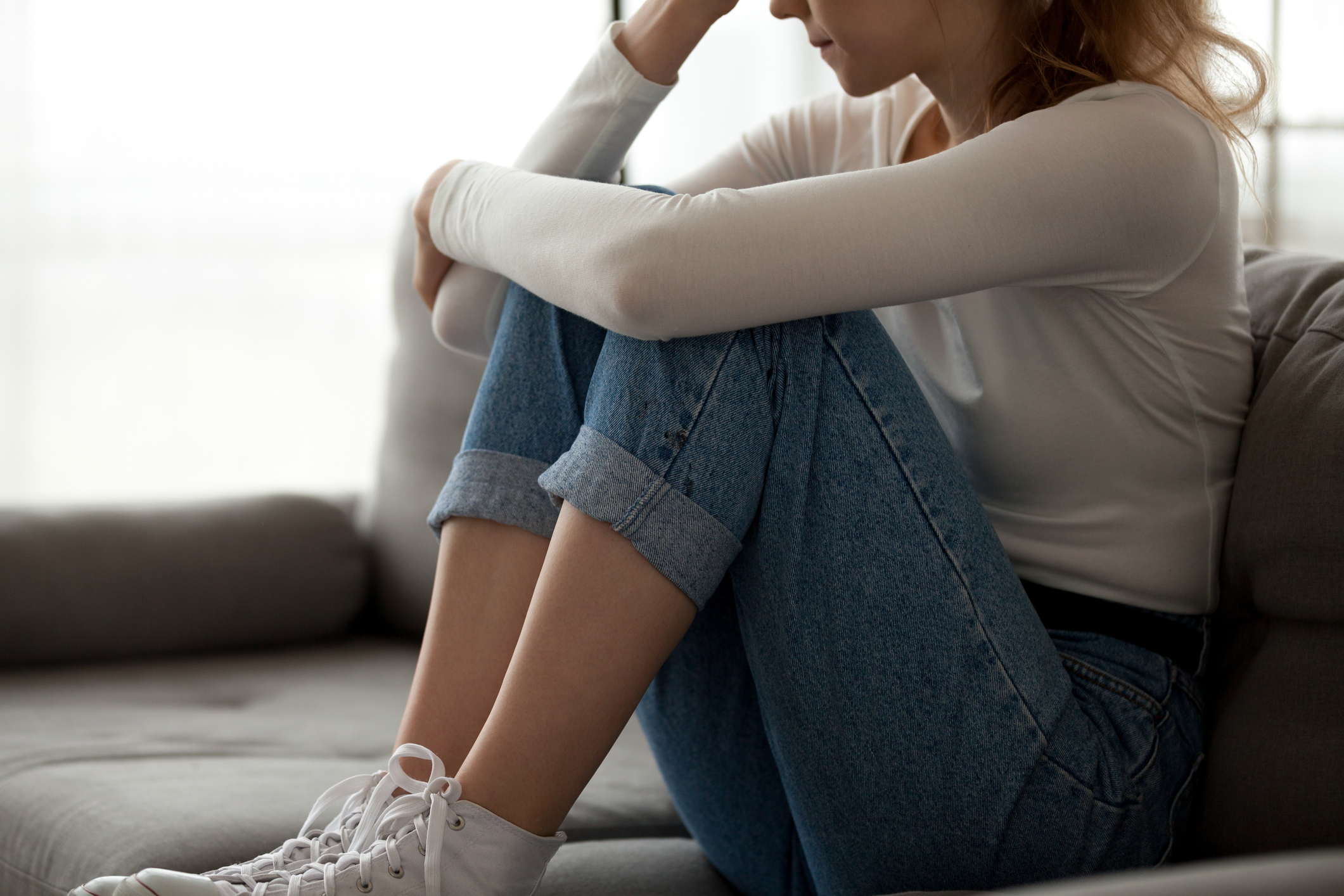 Woman sitting on couch in grief