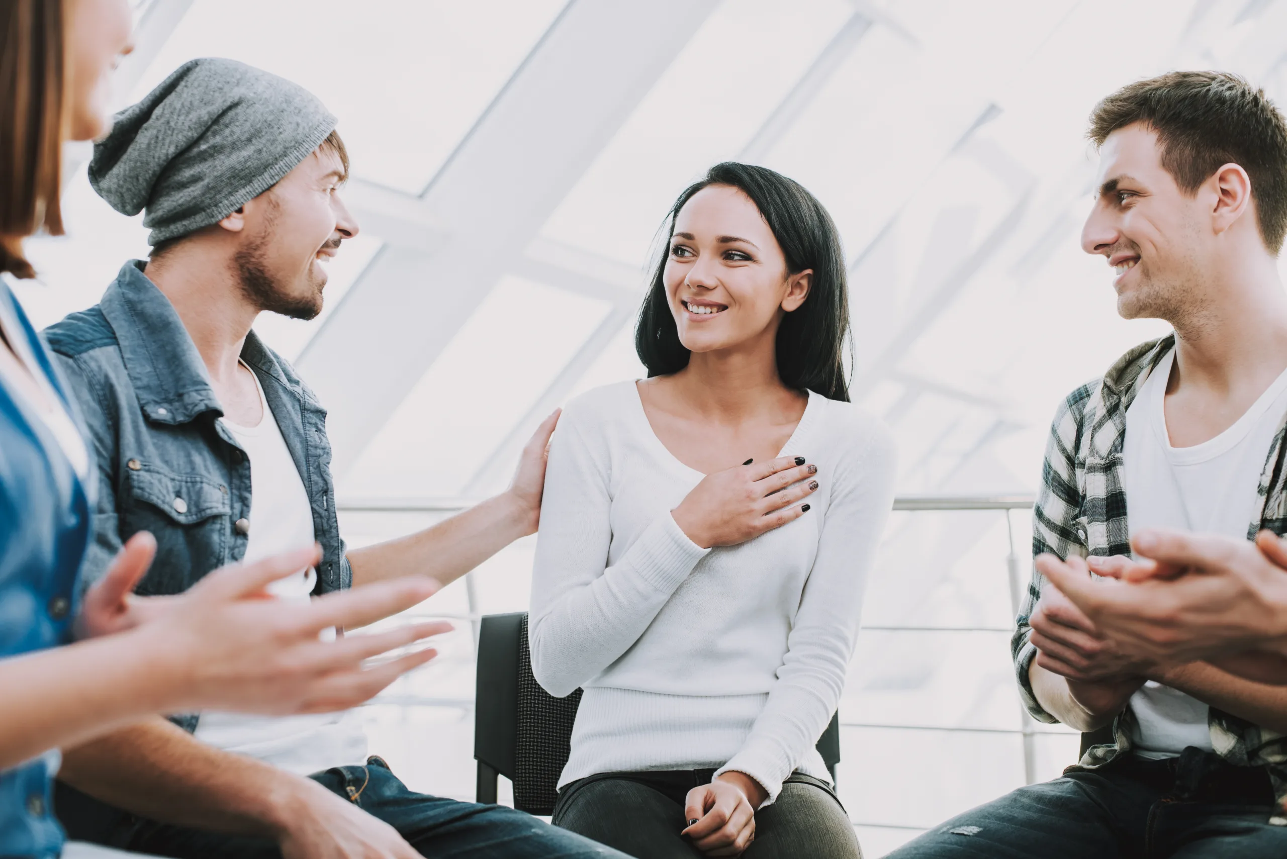 Group of young adults sitting around talking in a session