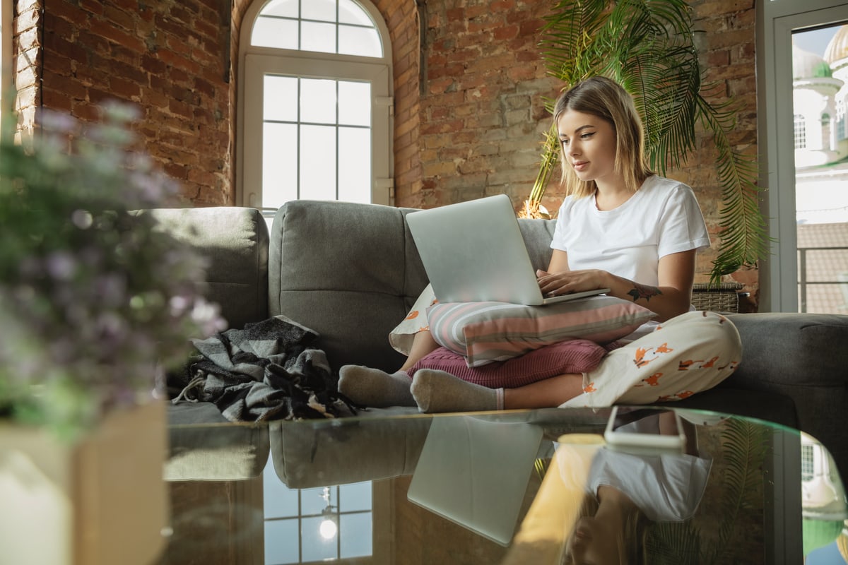 A young woman uses her laptop to talk with her therapist as part of a teletherapy substance abuse treatment program.