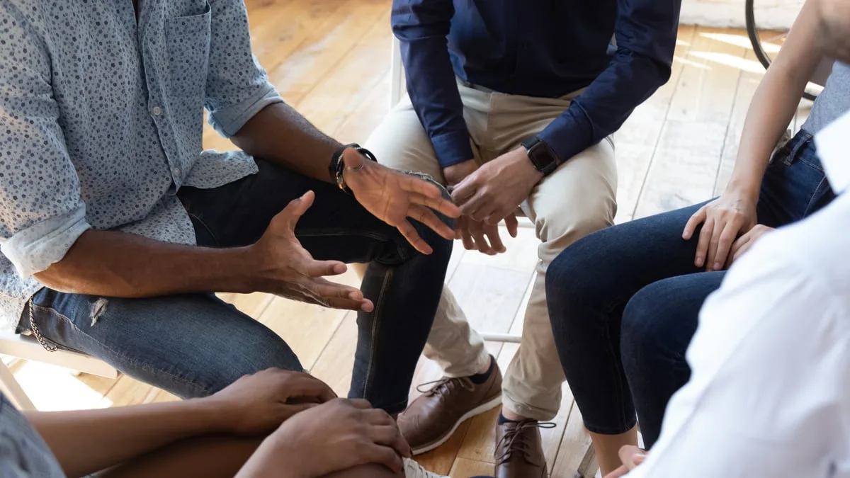 A counselor leads a group therapy session for patients in an outpatient rehab program.