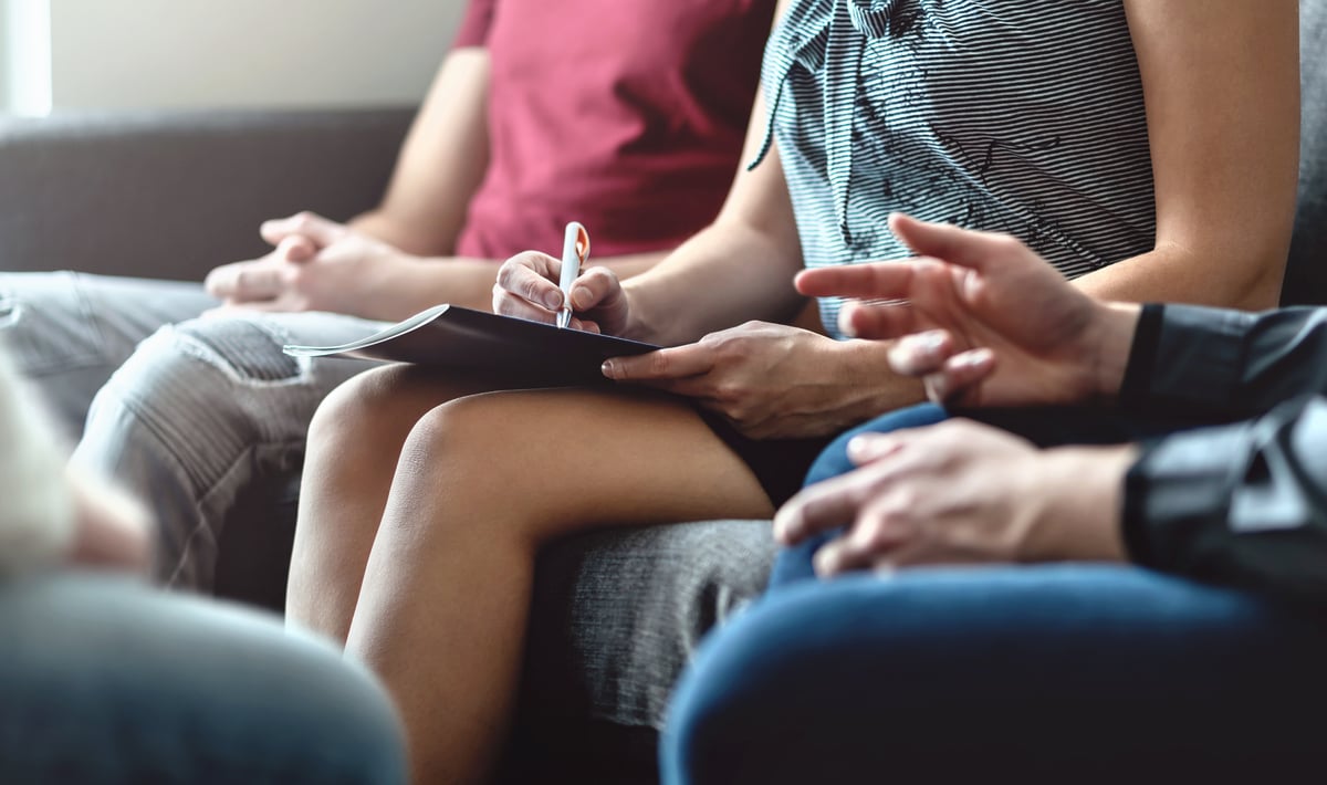 Several people participate in a group therapy session for alcohol abuse treatment.