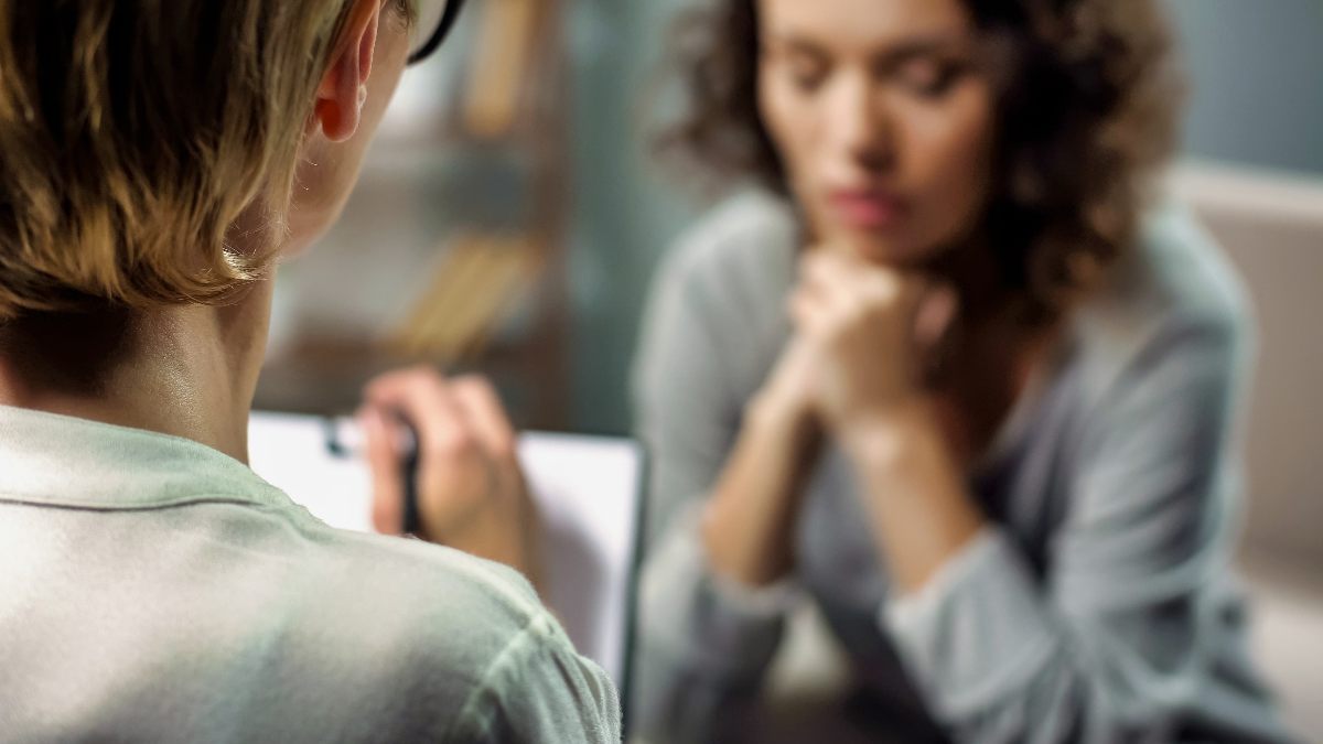 A young woman and a therapist practice motivational interviewing during a therapy session