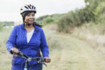 a-mature-african-american-woman-riding-a-mountain-bike-in-a-state-park-she-is-wearing-a-helmet-and-a-blue-jacket-looking-away-from-the-camera-with-a-confident-expression-stockpack-gettyimages A mature, African American woman riding a mountain bike in a state park. She is wearing a helmet and a blue jacket, looking away from the camera with a confident expression.
