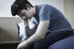 Depressed Young Man With Bandaged Wrists After Suicide Attempt