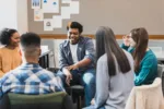 during-a-group-therapy-session-a-teenage-boy-gestures-as-he-talks-about-something-with-the-people-in-the-group-an-attentive-female-therapist-facilitates-the-meeting-stockpack-gettyimages During a group therapy session, a teenage boy gestures as he talks about something with the people in the group. An attentive female therapist facilitates the meeting.