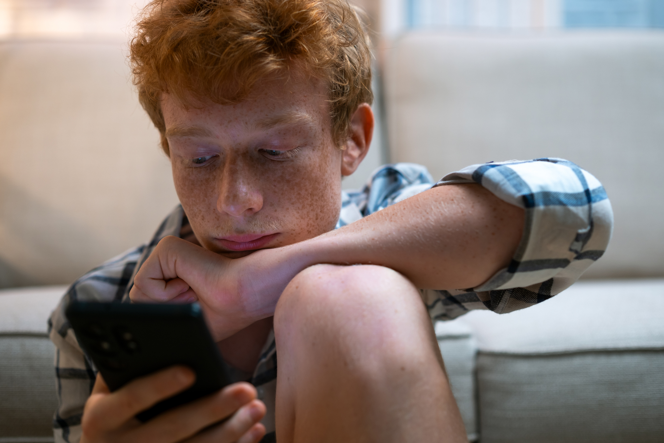 Young boy using phone with the dangers of digital drug market