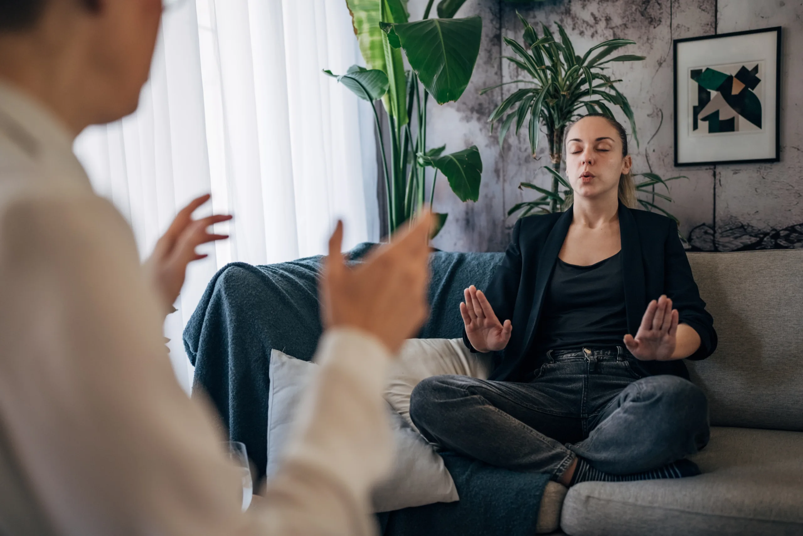 In a serene setting, one individual guides another through a calming breathing technique, fostering an atmosphere of peace and relaxation for motivational enhancement therapy
