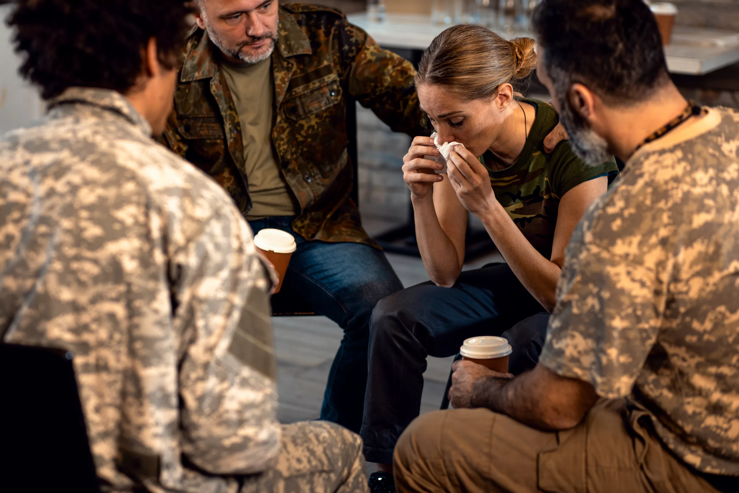 Group of diverse veterans talking during PTSD support group.