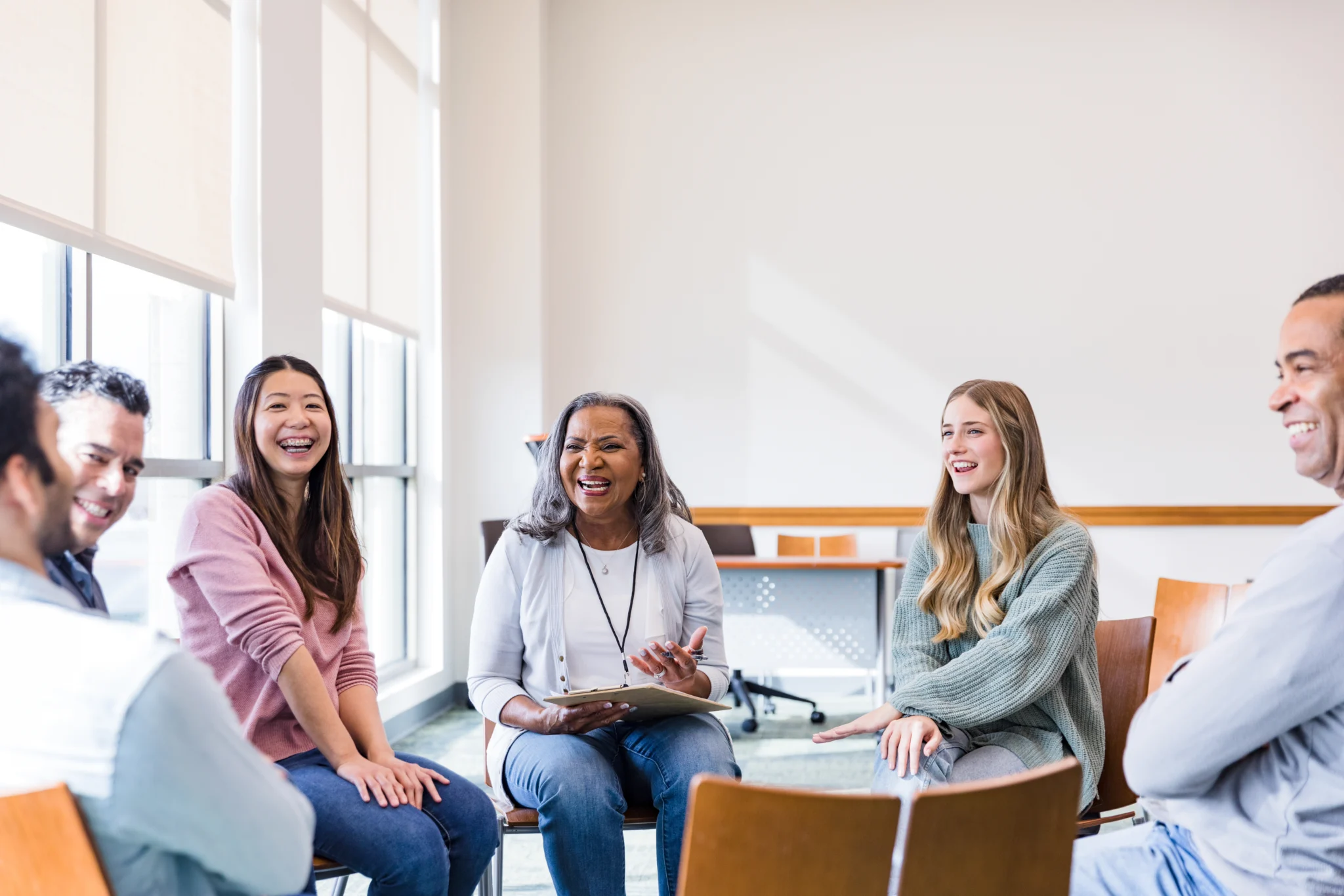 The smiling, cheerful multiracial group of people meet for a focus group.