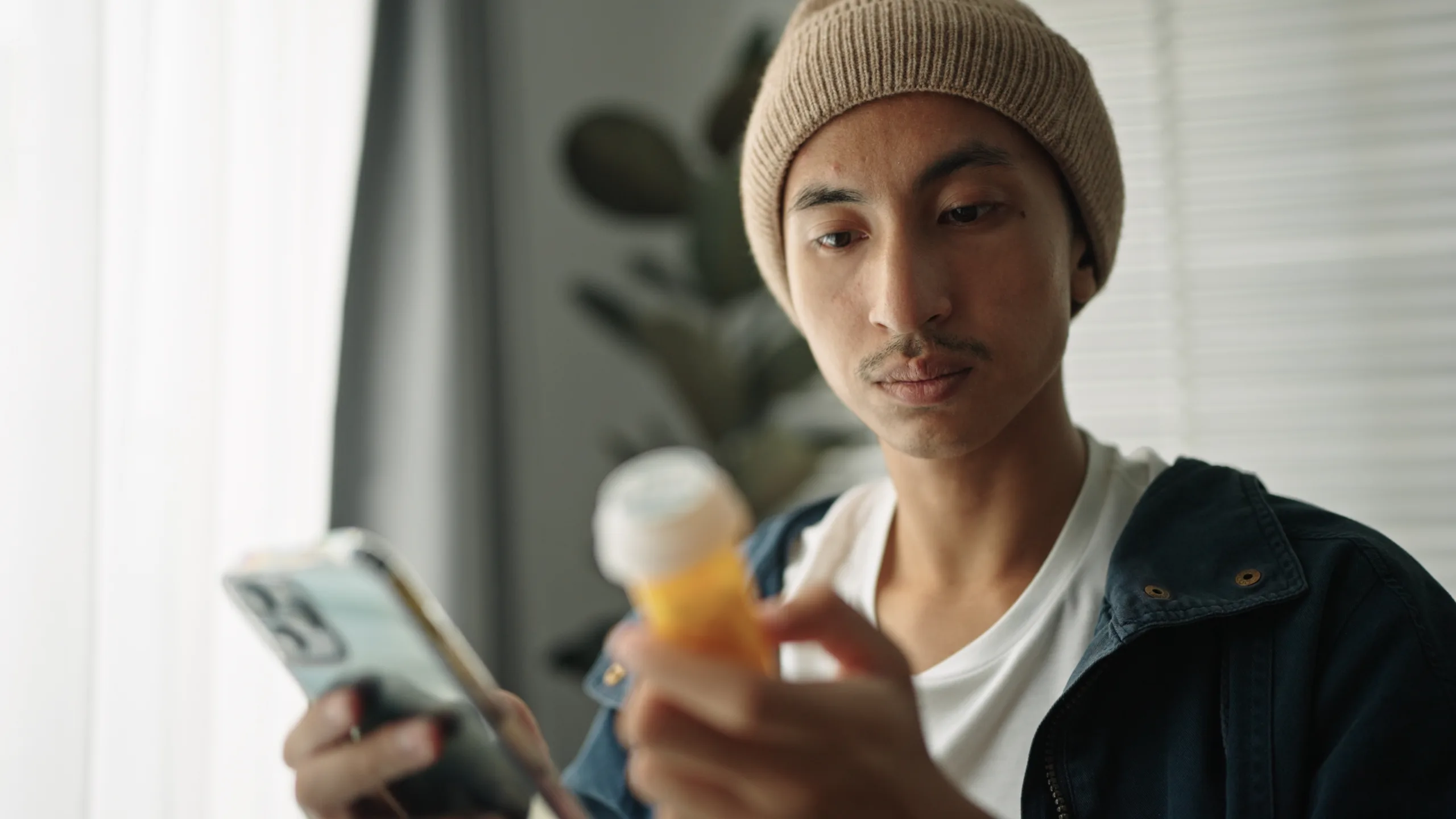Young asian man patient searching pills information on wheelchair.